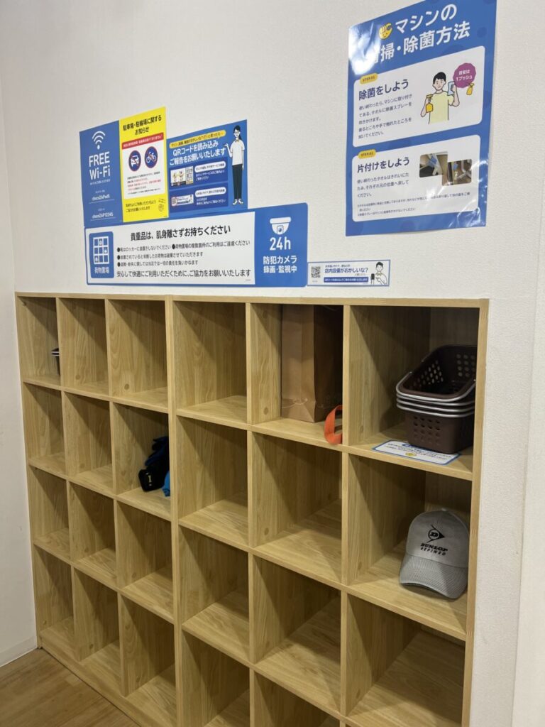 チョコザップの荷物置場。貴重品は肌身離さず・24時間防犯カメラ録画中の掲示があるオープン棚