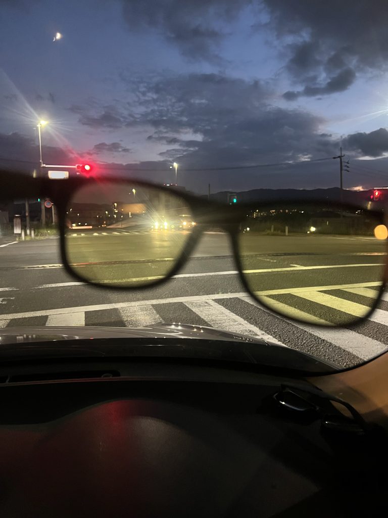 ナイトグラス越しに見た同じ交差点。景色が黄色みを帯び、ヘッドライトのにじみが小さく見える